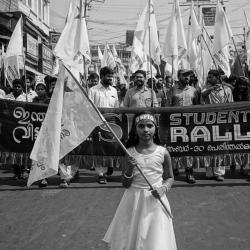 A young girl in India at the front of a student rally for social justice.