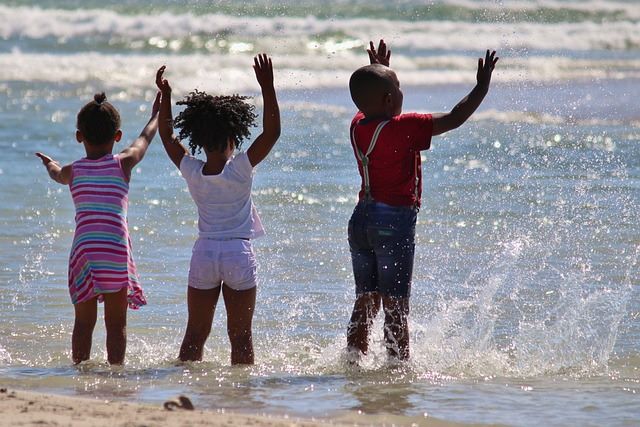 Three children in Africa, playing in the sea, as a symbol of hope for the developing world's future.
