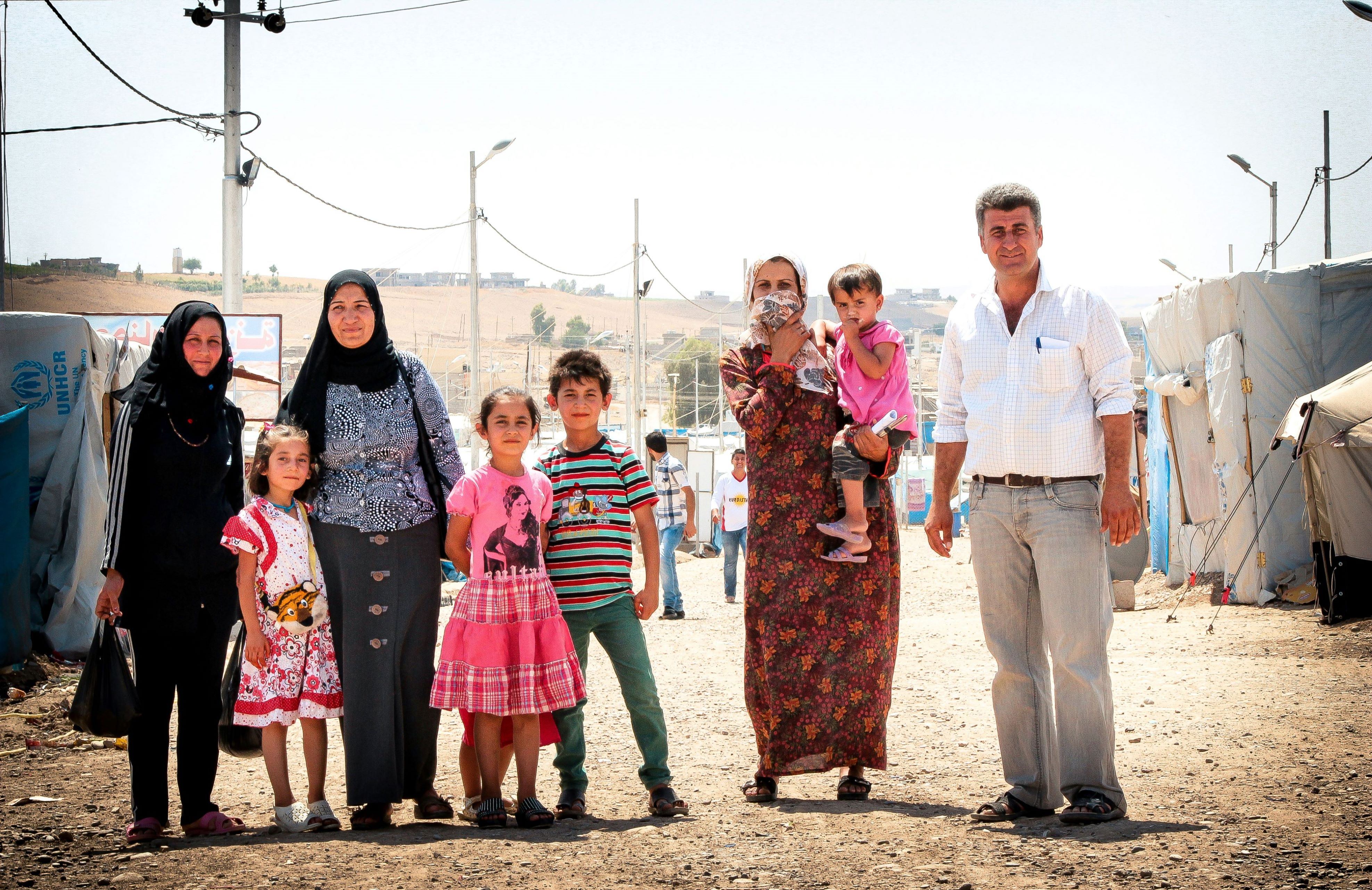 A family in a refugee camp. A displaced family in a refugee camp, consisting of a man, three women, and four children.