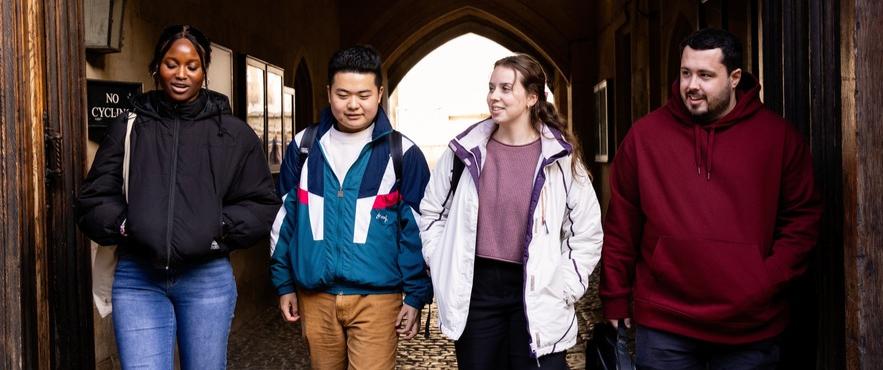 Four students walking through a College entryway
