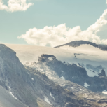 Image of two hot-air balloons travelling over mountains.