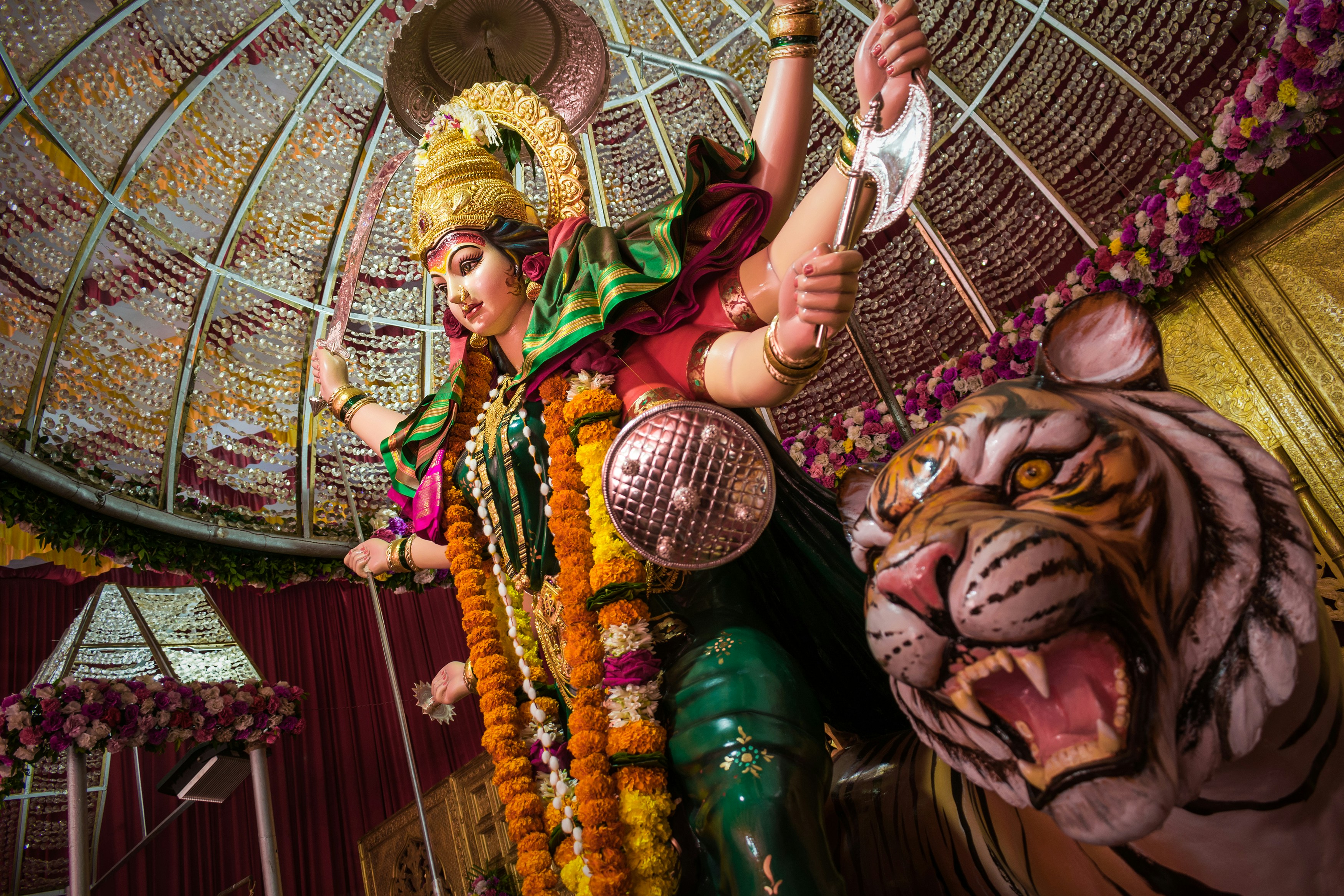 A cultural idol- statue of the mother goddess Maa Durga Devi in Mumbai, made in celebration of Durga Puja. She is depicted with six arms, wielding weapons such as a spear and an axe, and is flanked by a tiger.